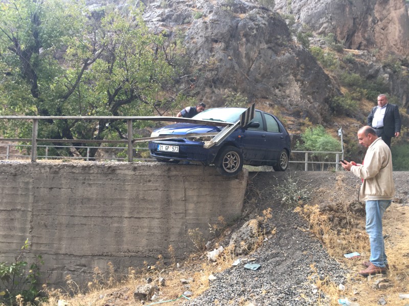 Kayganlaşan yolda kaza yapan otomobil köprüde asılı kaldı